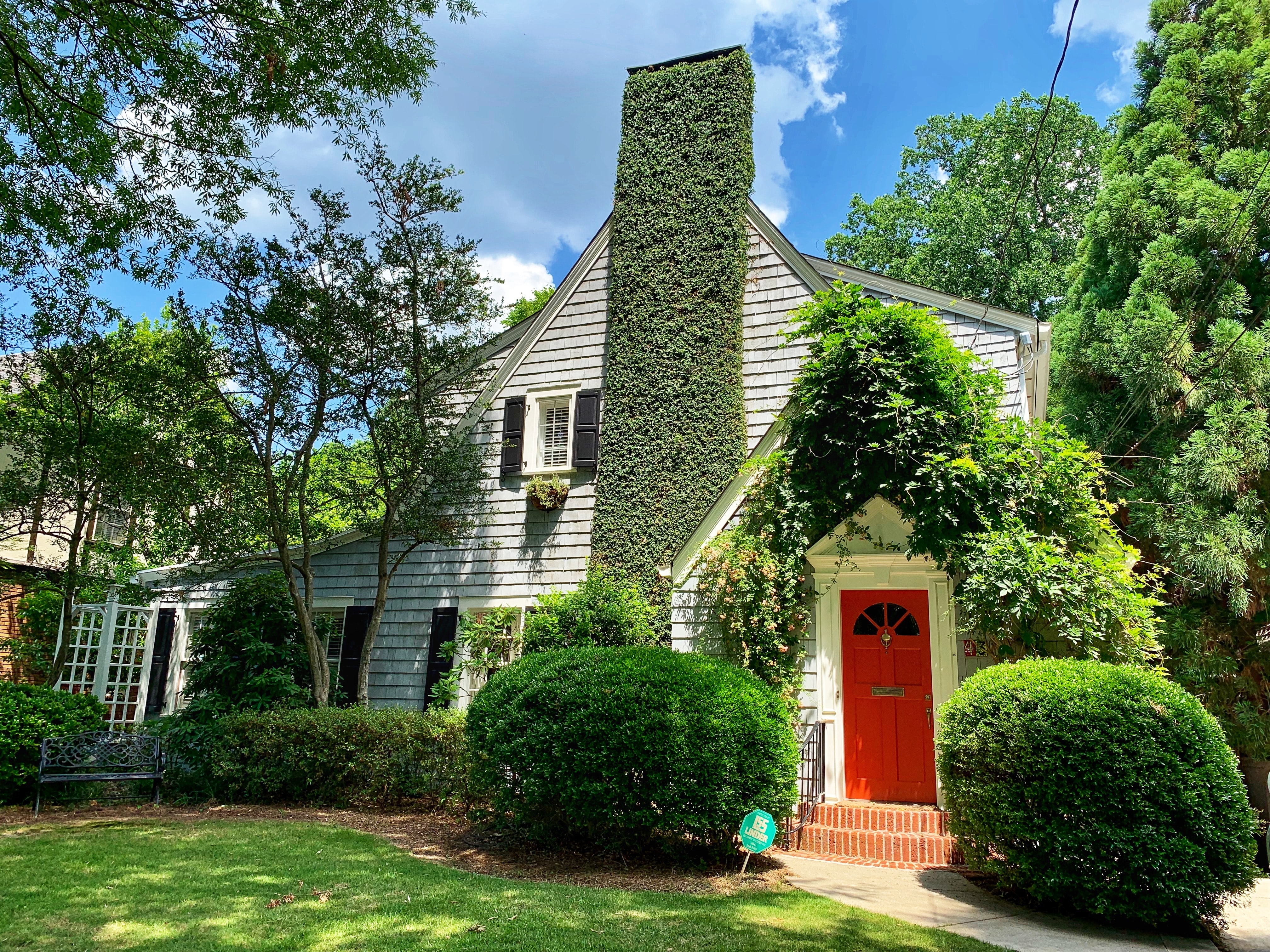 white house with red door and green ivy on chimney