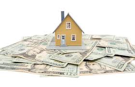 model of a yellow house sitting on a pile of $20 bills